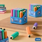 Colorful book and pencil shaped erasers displayed in a blue illustrated box titled Bookshelf Eraser.
