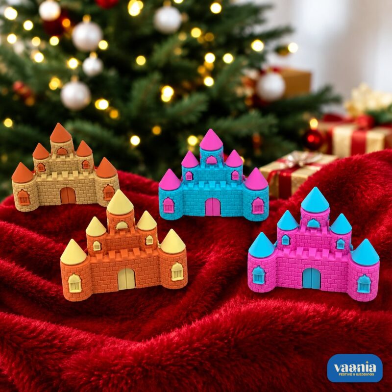 Four colorful castle erasers in gold, orange, blue, and purple resting on red velvet near a Christmas tree.