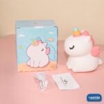 A glowing Sitting Unicorn Silicone Night Lamp with a colorful horn and pink wings on a pink background. - view 6