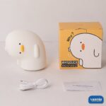 A glowing Why Duck Silicone Night Lamp resting inside a warm arched wall niche. - view 6
