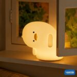 A glowing Why Duck Silicone Night Lamp resting inside a warm arched wall niche. - view 3