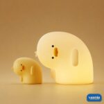 A glowing Why Duck Silicone Night Lamp resting inside a warm arched wall niche. - view 5