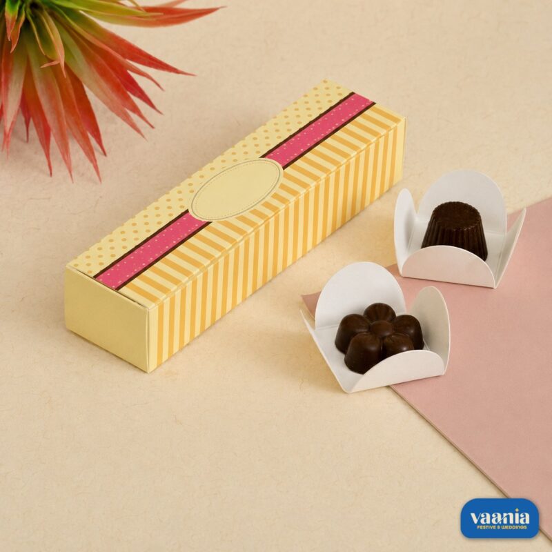 A yellow striped and dotted 4-Cavity Box displayed with two gourmet chocolates in white liners.