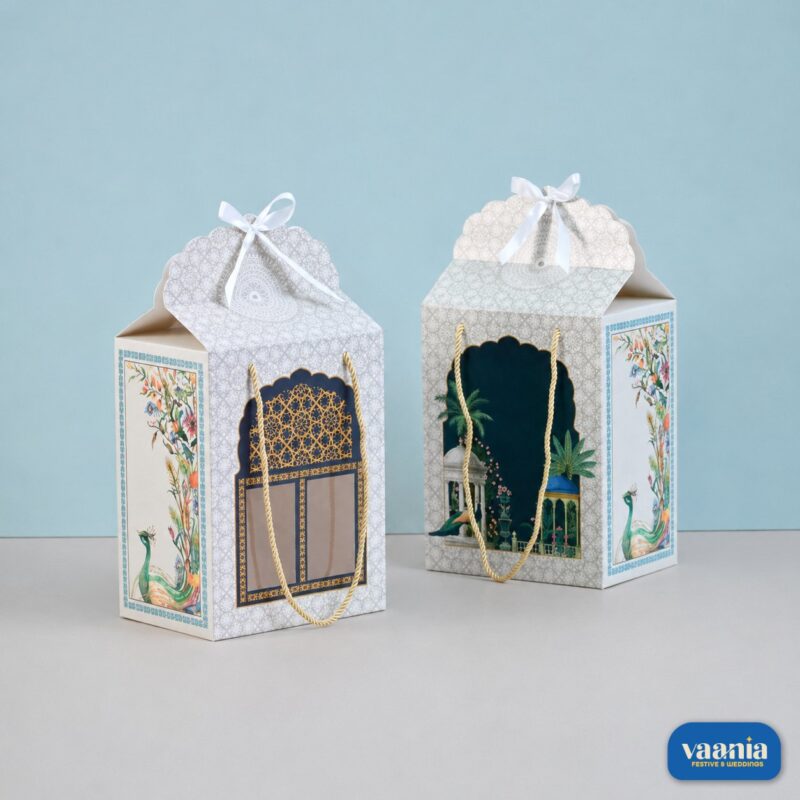 Two Window Hamper Boxes with peacock art, gold handles, and white ribbons on a blue background at Vaania.