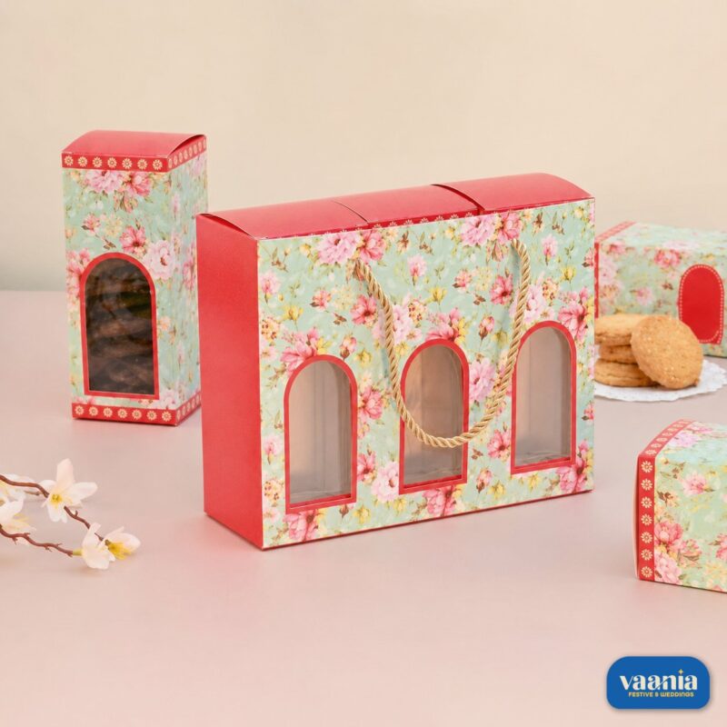 A floral Hamper Bag Set with three arched windows and three matching inner boxes filled with cookies on a pink surface.