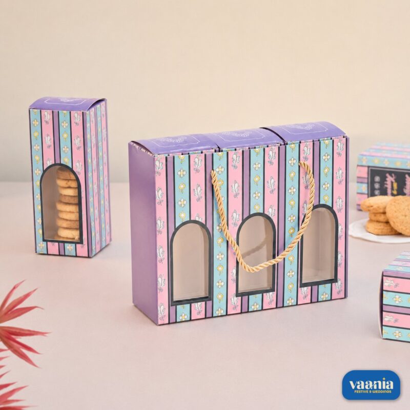 A floral purple and blue Hamper Bag Set containing three windowed boxes filled with cookies by Vaania.