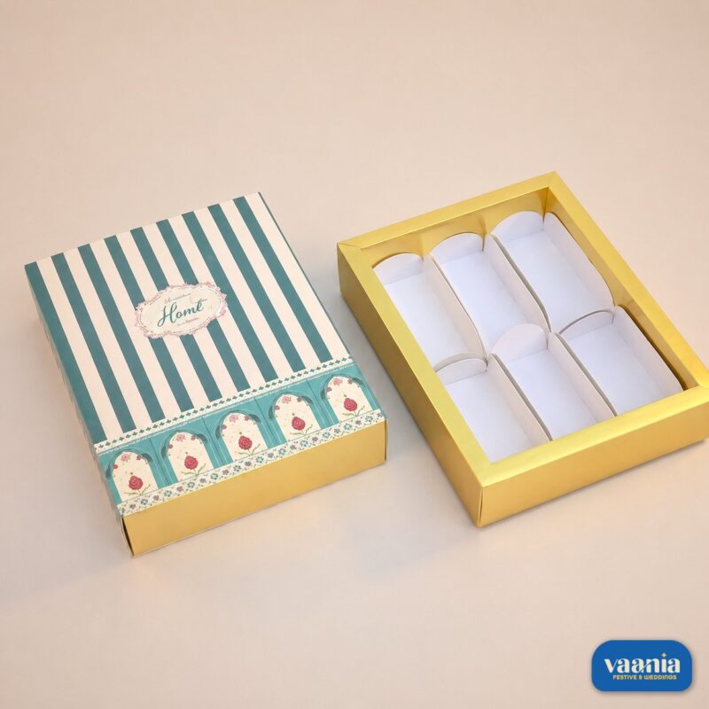 A teal striped sliding box with floral accents next to its gold six-cavity insert for Sliding Box - Cavity Box.