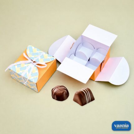 An orange Multi Purpose 4 Cavity Box with a white ribbon alongside an open box showing internal dividers and chocolates.