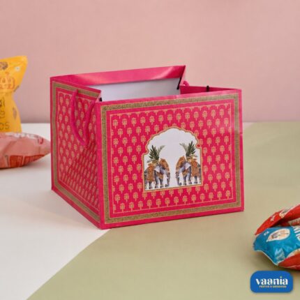 A pink square Gift Carry Bag with elephant illustrations and gold patterns on a white and green surface.
