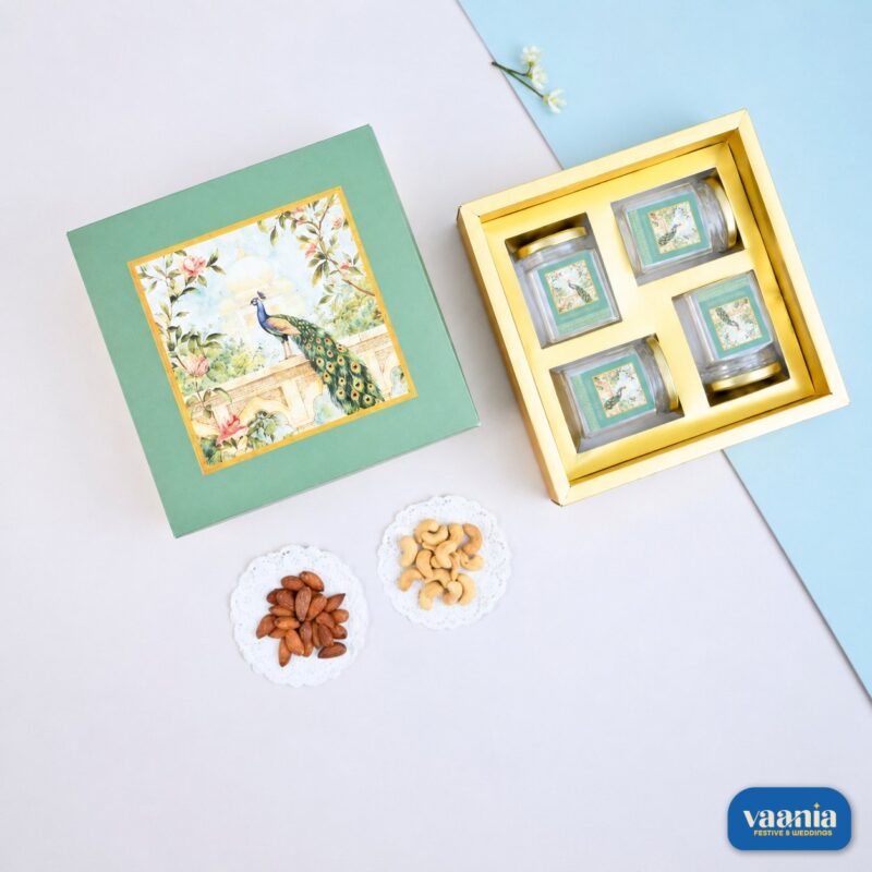 A green Top-Bottom Hamper with peacock art open to reveal four PET jars and loose almonds and cashews.