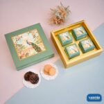Top-Bottom Hamper with four small boxes featuring peacock illustrations and assorted cookies displayed on the side.
