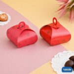 Two red Multi Purpose Boxes with star patterns and circular handles on a pink and yellow background.
