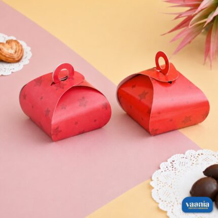 Two red Multi Purpose Boxes with star patterns and circular handles on a pink and yellow background.