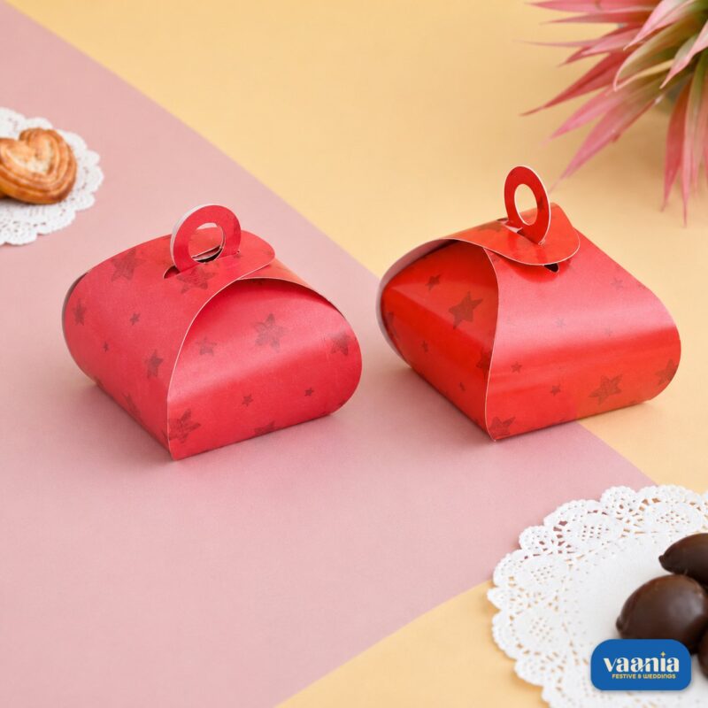Two red Multi Purpose Boxes with star patterns and circular handles on a pink and yellow background.