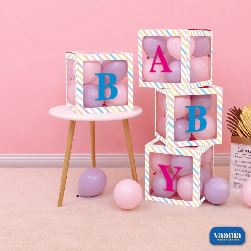 Four Multi Purpose Window Boxes spelling BABY filled with pink and purple balloons on a table and floor.
