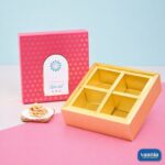 A pink Top-Bottom Hamper with 4 compartments, featuring a gold interior and patterned lid.