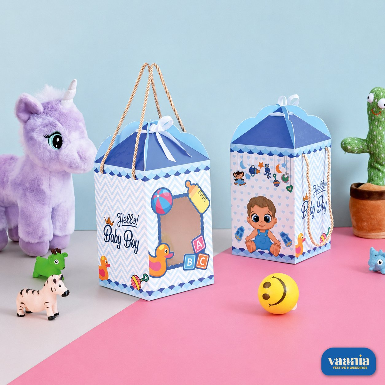 Hamper Box (Baby Boy) by Vaania Dhanbad Two blue and white baby boy hamper boxes with rope handles featuring baby illustrations next to a purple stuffed horse.