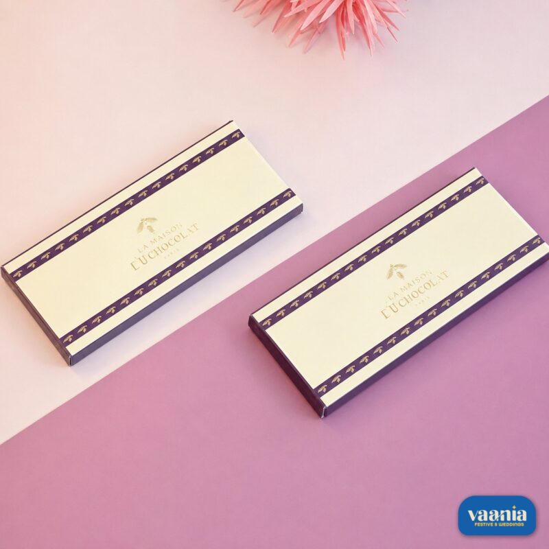 Two elegant cream and purple Premium Chocolate Bar Boxes with gold leaf lettering on a two-tone pink background.