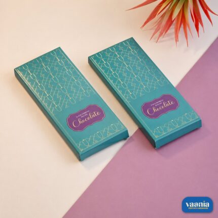 Two Premium Chocolate Bar Boxes with teal packaging and gold leaf geometric patterns on a two-tone background.