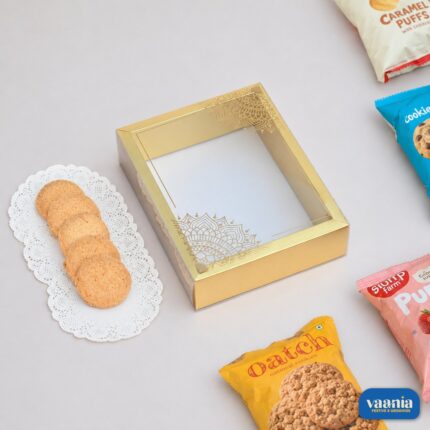 A luxury Sliding PVC Box with gold mandala patterns displayed next to cookies and snack packets.